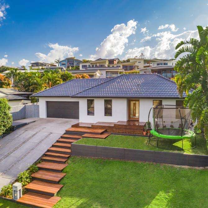 A house surrounded by a spacious yard and featuring a long driveway leading up to the entrance. | Featured Image for the Investment Property Buyers Agent Brisbane service landing page