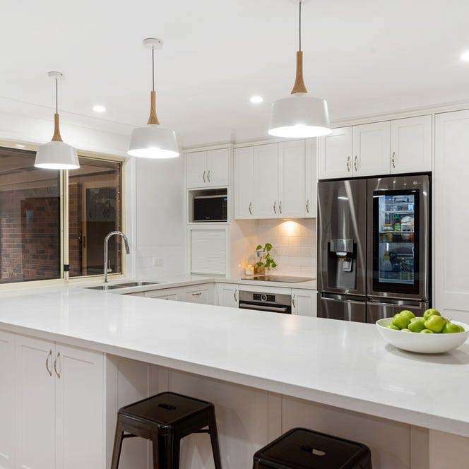 Bright white kitchen with a spacious central island, showcased by an overseas buyers agent Brisbane for modern home buyers.